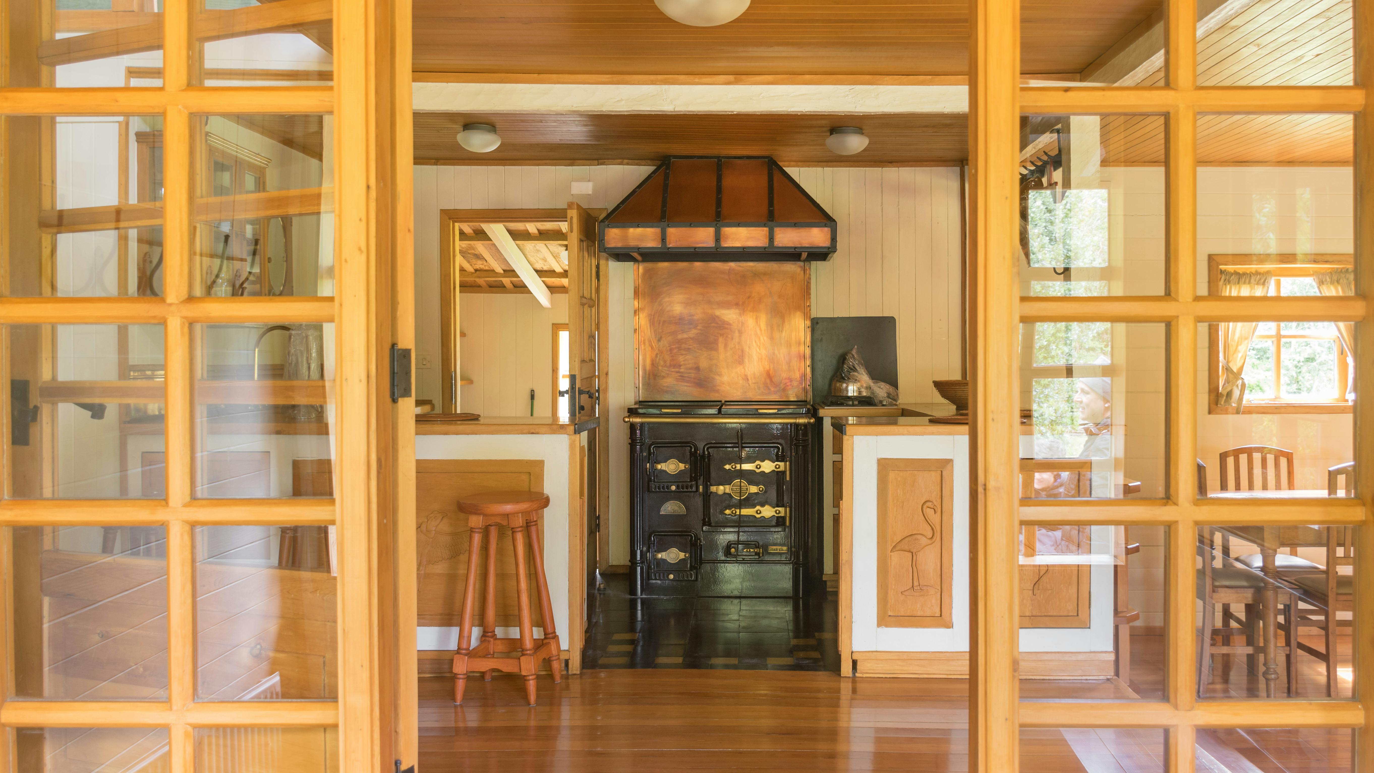 Warm rustic kitchen interior featuring a vintage stove and wooden furniture, offering a glimpse of nostalgic charm.